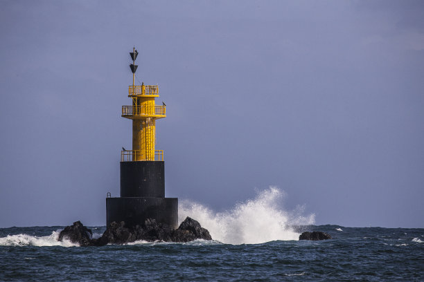 多云天蓝色大海中的灯塔图片下载