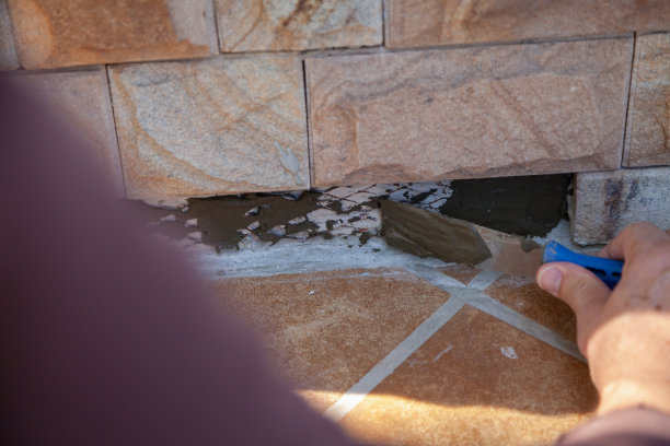 手将砂浆涂抹到基础近景墙上图片下载