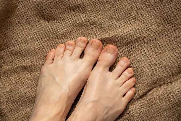 女性光着脚站在旧木地板上图片下载