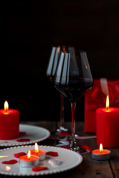 情人节庆祝活动。红酒酒杯，爱心，礼盒，明信片在黑暗的木制背景。节日快乐。餐桌装饰喜庆，气氛浪漫图片下载
