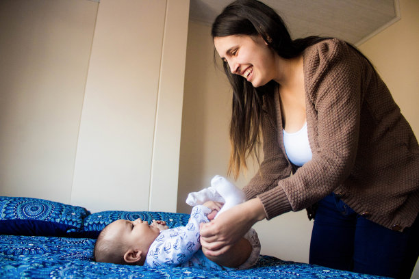 年轻母亲在床上与新生儿一起做肌肉运动的浅景深照片图片下载