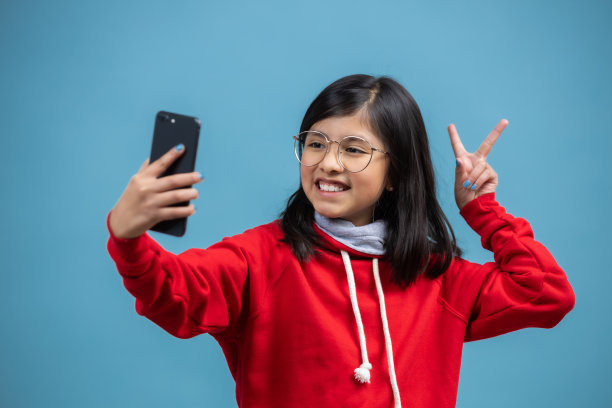 一个西班牙女孩用和平手势自拍图片下载