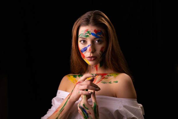 一个漂亮的年轻白人妇女的肖像与水粉画的身体上的黑色背景。图片下载