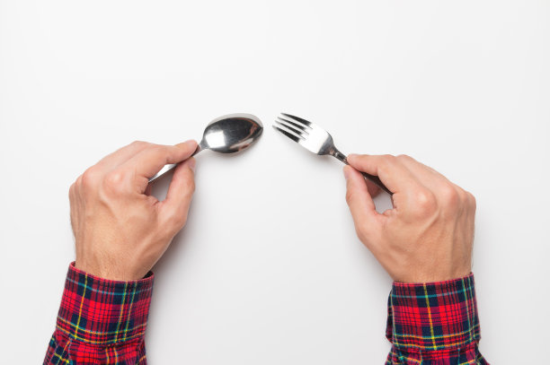 俯视图，特写男性手勺和叉子在空白色的桌子上，饥饿的客户图片下载