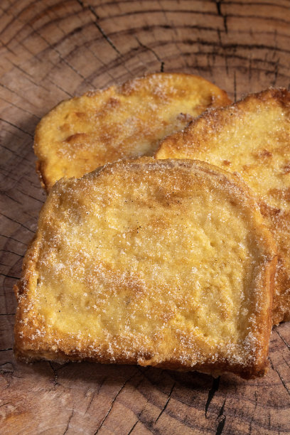 (Torrijas)在牛奶中浸泡的油炸面包，加入香草、肉桂、柠檬和鸡蛋，背景是木制的。典型的复活节甜点。传统节日美食的概念。图片下载