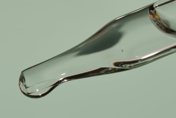 近距离移液管滴一滴天然有机精华液用于面部或精华有机油用于年轻化。在一个时尚的浅绿色背景。高质量照片图片下载