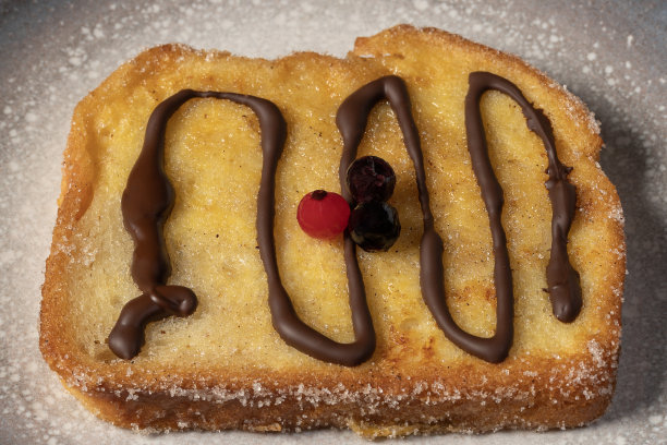 在牛奶中浸泡的面包，加香草、肉桂、柠檬和鸡蛋，放在灰色的盘子里。典型的复活节甜点。传统的节日烹饪概念。图片下载