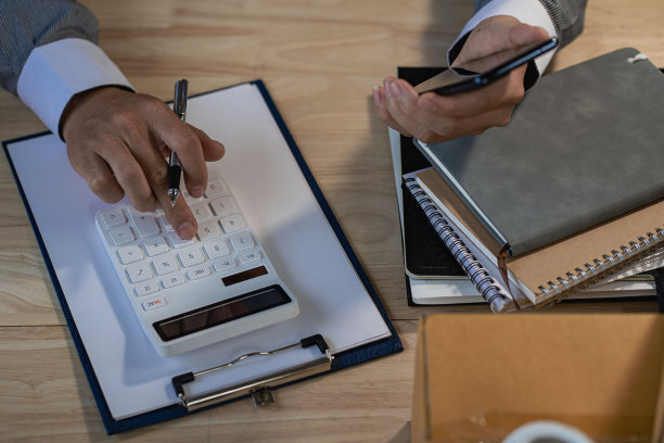 商人计算财务报告和使用手机在家庭办公室得到结果。家庭会计核算概念。前视图。图片下载