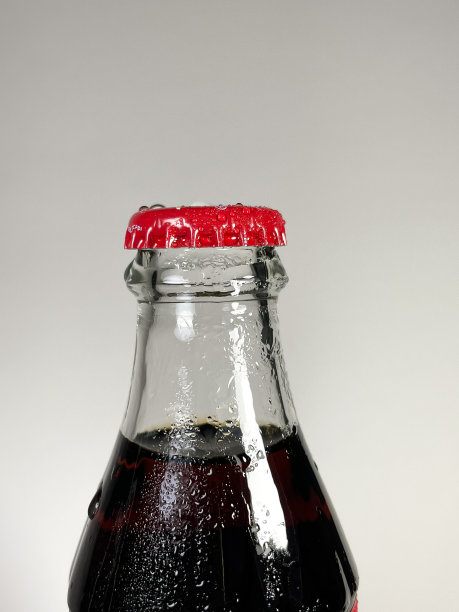 用白色背景上有水滴的红色瓶盖的玻璃瓶饮用图片下载