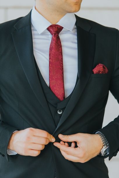 一个男人扣上黑色西装的垂直镜头图片下载