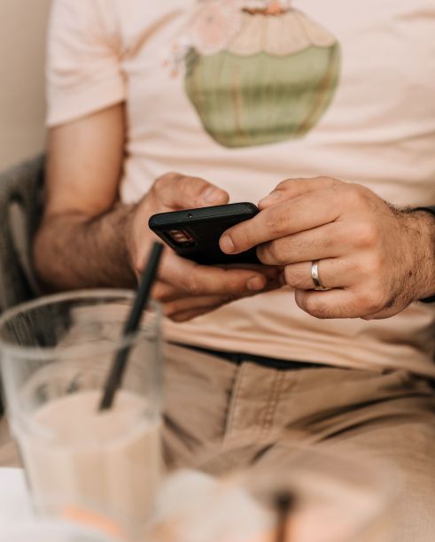 白人男子一边喝奶昔一边看手机图片下载