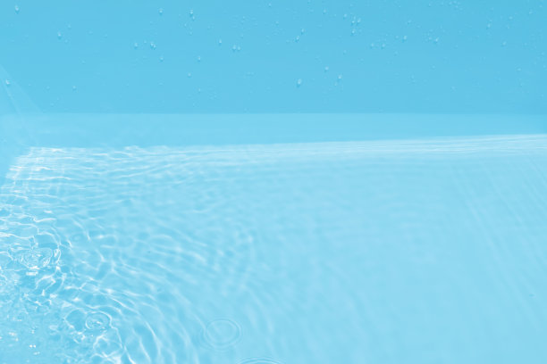 离焦模糊透明蓝色颜色清晰平静的水面纹理与飞溅和气泡。潮流抽象的自然背景。水波在阳光下复制空间。蓝色水彩闪光图片下载