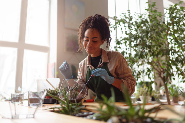 快乐微笑的女人花店制作多肉植物成分在花卉设计工作室图片下载