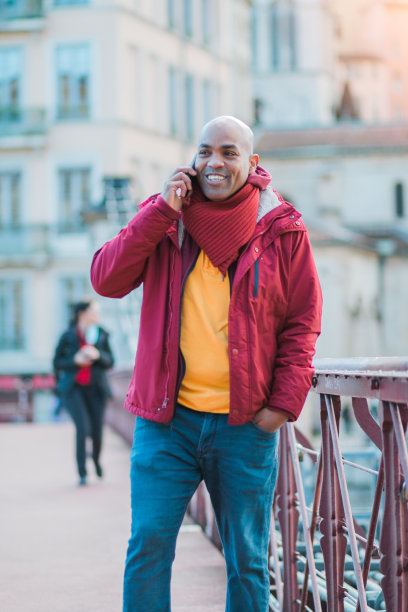 一个拉丁秃头男人走在街上打电话图片下载