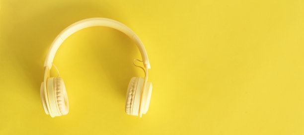 黄色背景耳机的俯视图。图片下载