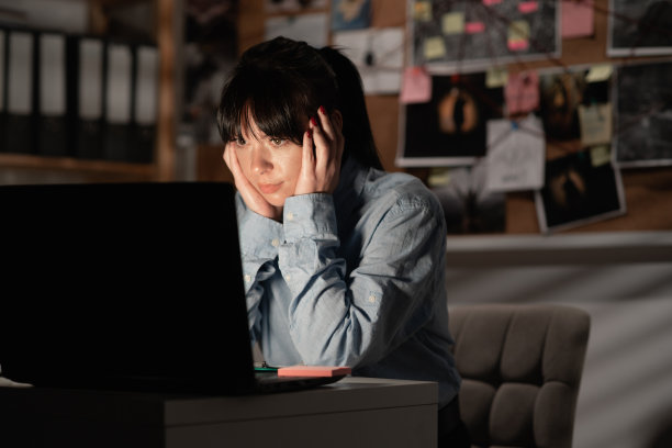 沮丧的侦探在办公室处理证据，工作时使用电脑，没有工作理念。图片下载