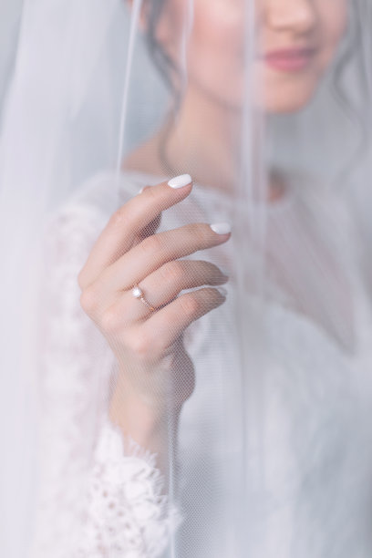 幸福的新娘在手指上戴着美丽的钻石戒指的地方伸出手来。图片下载