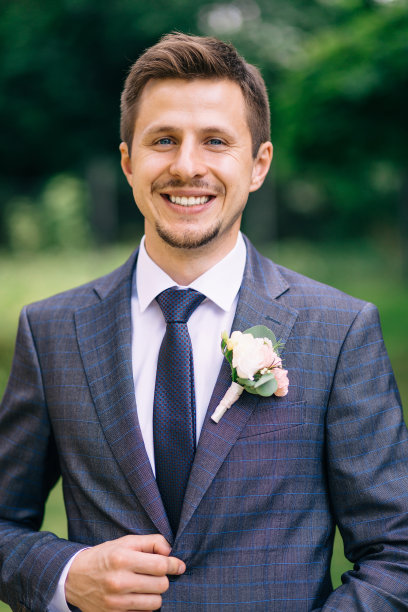 婚礼前，身着西装、面带微笑的新郎走在大街上。图片下载