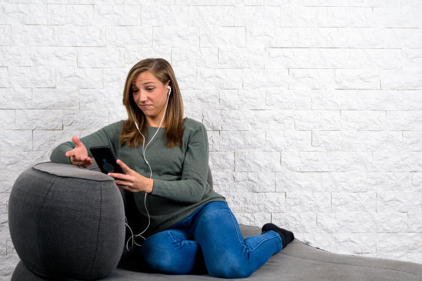 怀疑的女人在沙发上打手势图片下载