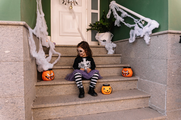 一个小女孩在户外的楼梯上打扮成女巫的特写镜头图片下载