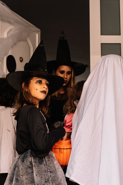 年轻的白人女子伪装成女巫，给孩子们表演魔术图片下载