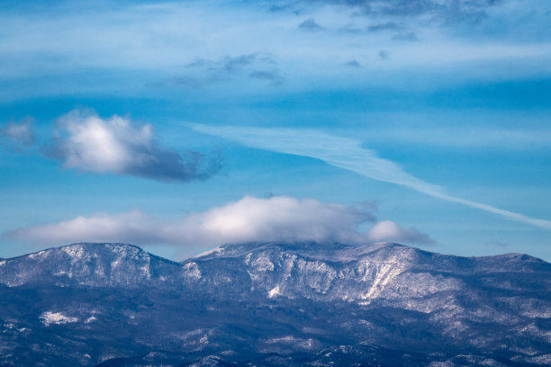 蓝天中薄云覆盖部分山峰的风景图片下载