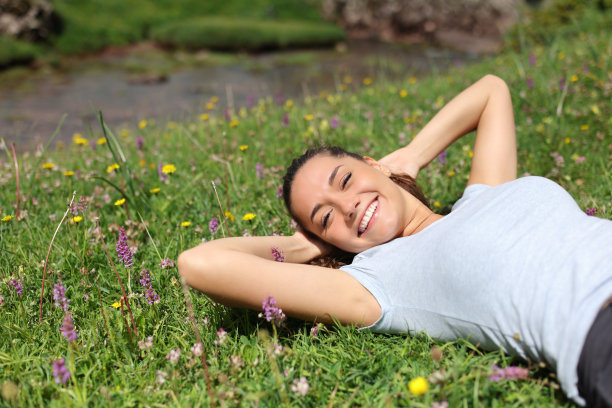 河边草地上放松的女人图片下载