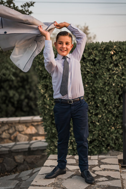 一个穿着正装的可爱男孩摆姿势的垂直镜头图片下载