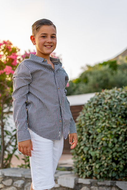 一个穿着正装的可爱男孩摆姿势的垂直镜头图片下载