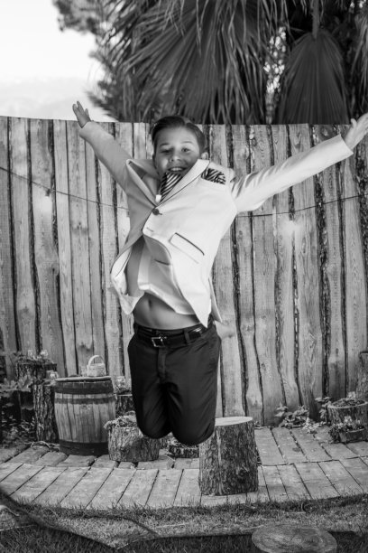 一个小男孩跳跃的垂直灰度特写。图片下载