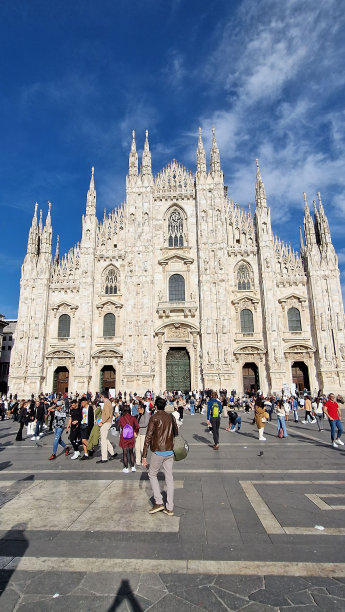 在阳光明媚的一天，意大利米兰大教堂前人群的垂直拍摄图片下载
