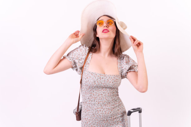 旅行的概念。年轻的游客女子手提箱和帽子在一个时尚肖像上的白色背景图片下载