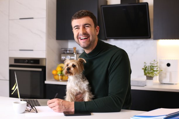 一个带着狗在家工作的男人图片下载