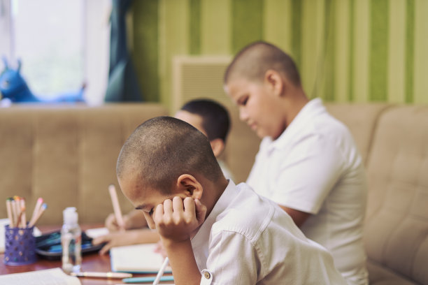 男性学生在家里上在线课时在课本上写字的画面图片下载