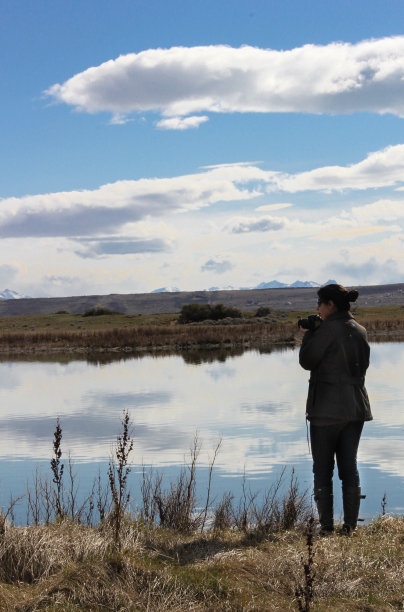 一个女人在河边拍照的背影图片下载