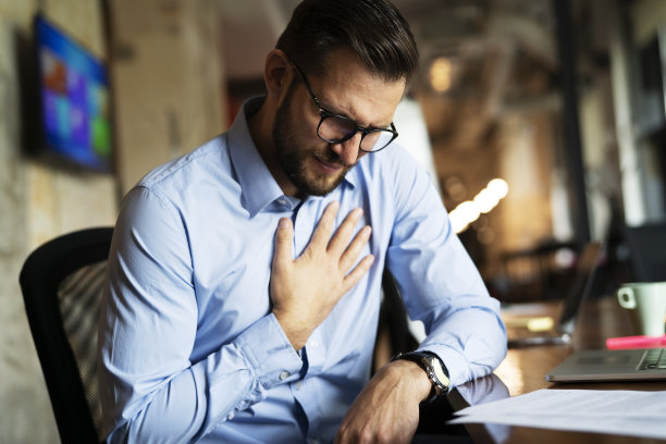 一个男人坐在办公室里用笔记本电脑工作。图片下载