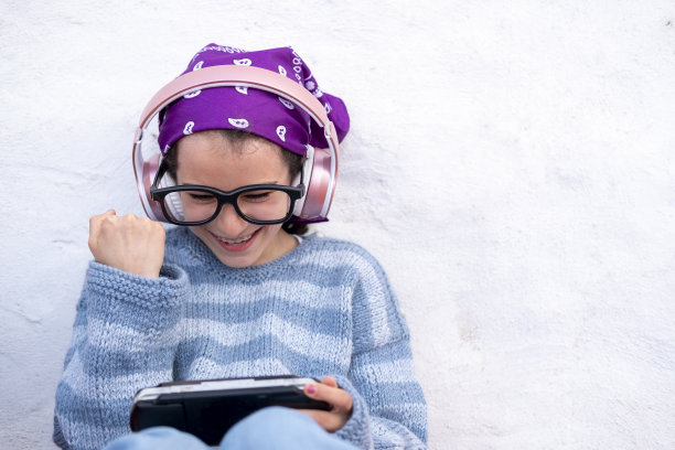 快乐的白人女孩戴着耳机和眼镜使用一个小工具图片下载