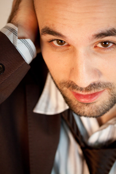 一个穿着西装的年轻白人男性的垂直肖像图片下载