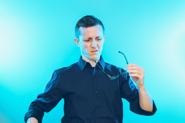 一名美国男子拿着眼镜，一脸恼怒图片下载