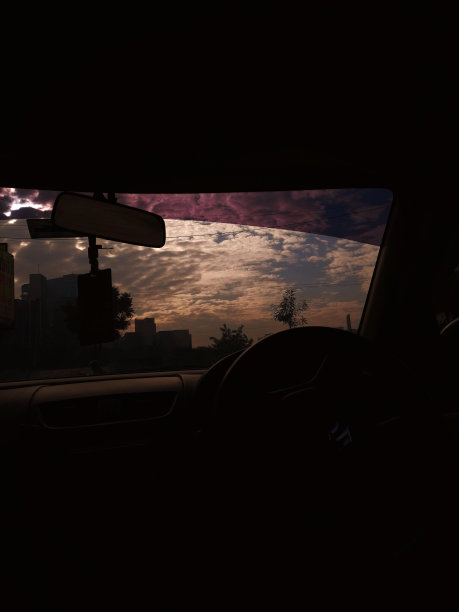 垂直剪影拍摄的汽车内部与多云的天空可见透过挡风玻璃图片下载