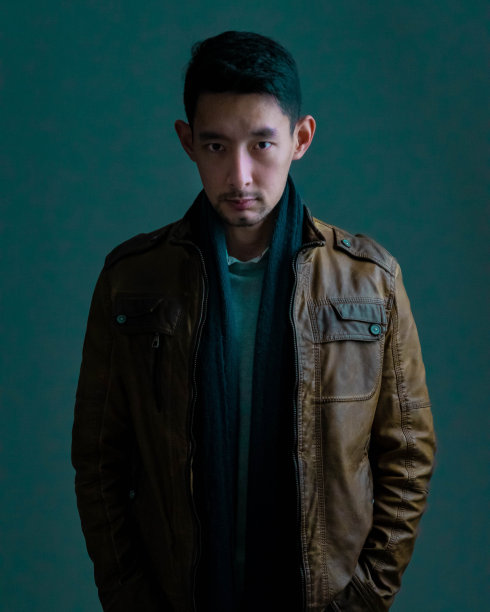一个穿着棕色皮夹克的严肃英俊的东亚男人的肖像图片下载