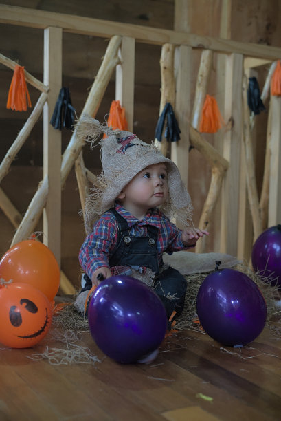 一个婴儿与万圣节气球和装饰的垂直照片图片下载