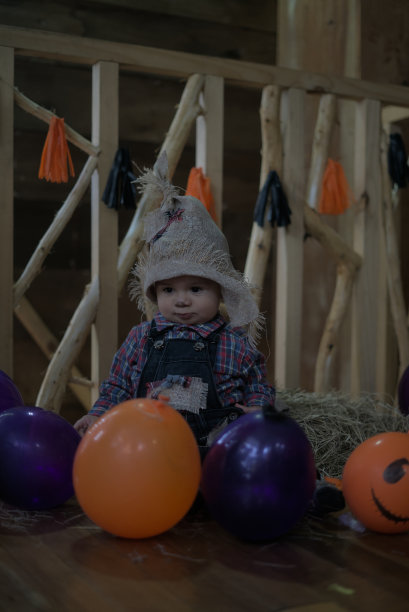 一个婴儿与万圣节气球和装饰的垂直照片图片下载