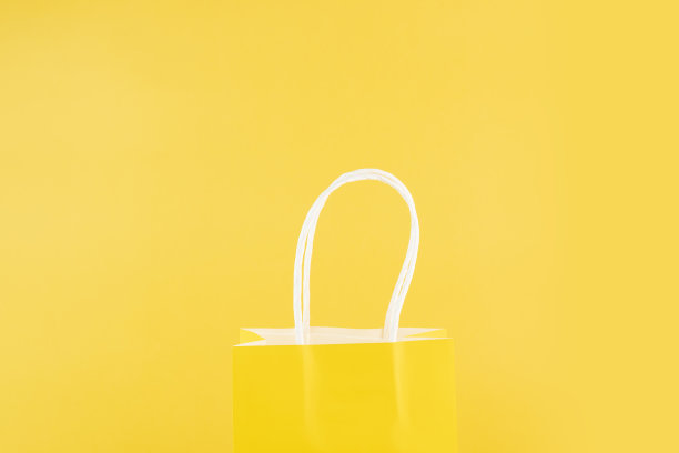 购物袋在黄色背景，购买购物者，销售和折扣，复制空间，单色，一种颜色图片下载