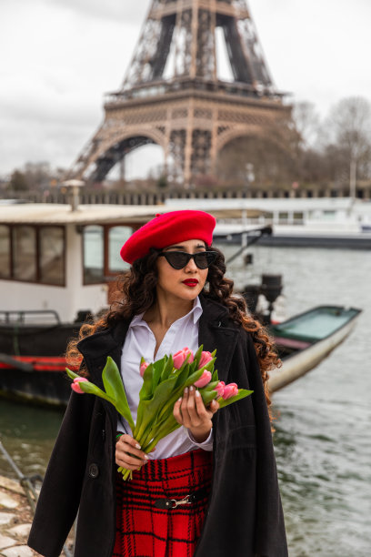 一个戴着红帽子的时髦女孩在埃菲尔铁塔前摆姿势的选择性聚焦镜头图片下载