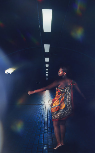 一名非洲妇女走在隧道的人行道上图片下载