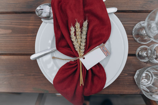 木桌上有盘子、小穗、毛巾和玻璃杯图片下载