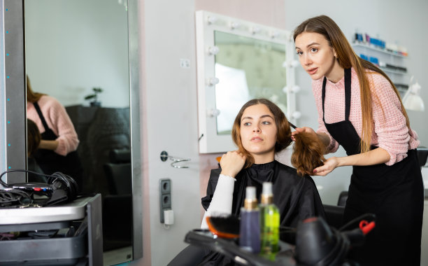 年轻女子讨论理发与专业女理发师图片下载