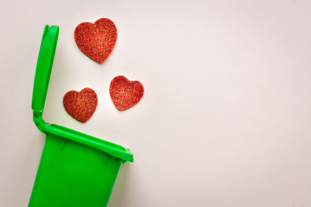 爱情的终结，反情人节，心碎的概念，心掉进垃圾桶图片下载