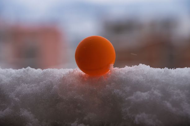 漂亮的橙色乒乓球在雪地里图片下载
